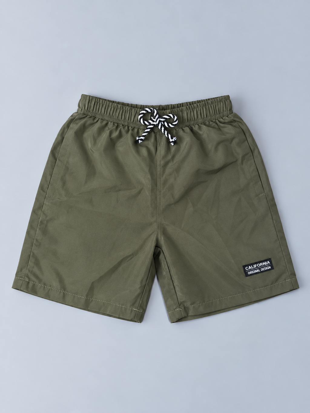 Boys olive green casual shorts with elastic waistband, black and white drawstring, side pockets, and small California patch
