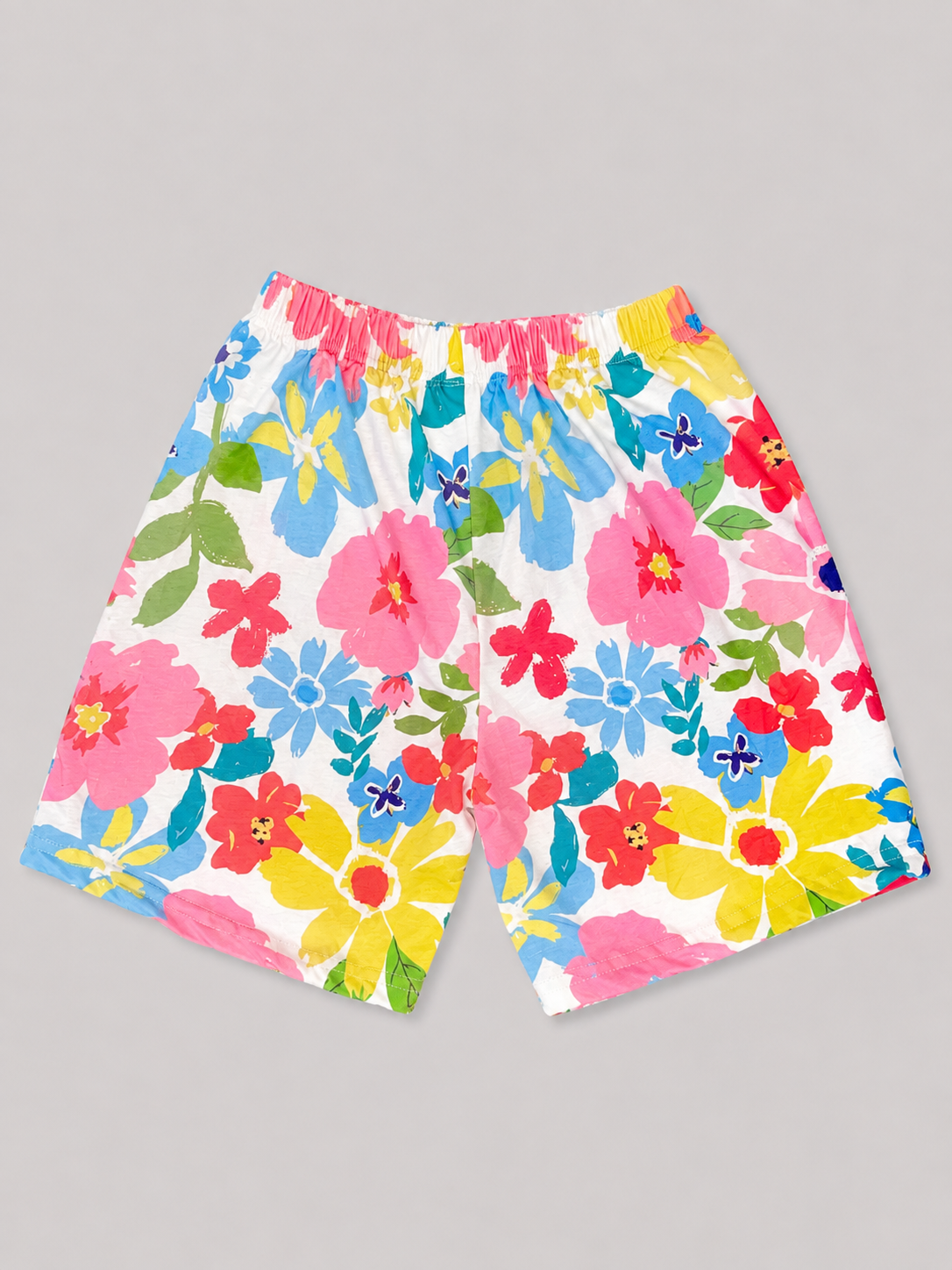 Colorful floral print girls' shorts featuring a comfortable elasticized waistband and vibrant pink, blue, yellow, red, and green flowers. Perfect for summer outfits and everyday wear.