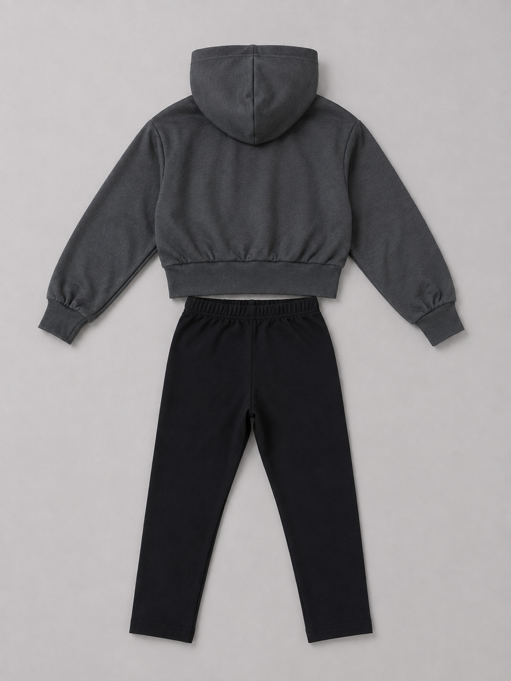 A two-piece clothing set featuring a dark gray cropped hoodie with long sleeves and black drawstring pants.