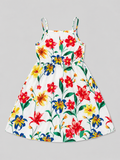 A sleeveless white sundress with thin straps and a colorful floral print featuring red, yellow, and blue flowers with green leaves, shown flat against a solid gray background.
