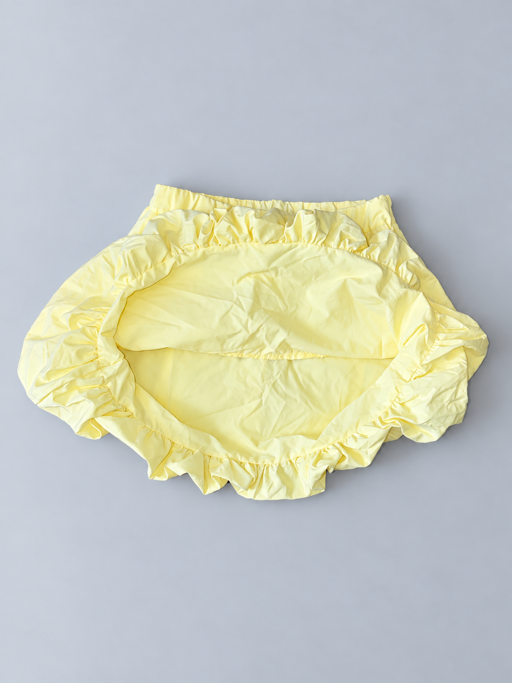 Interior view of girls pale yellow bubble-hem skirt showing layered construction