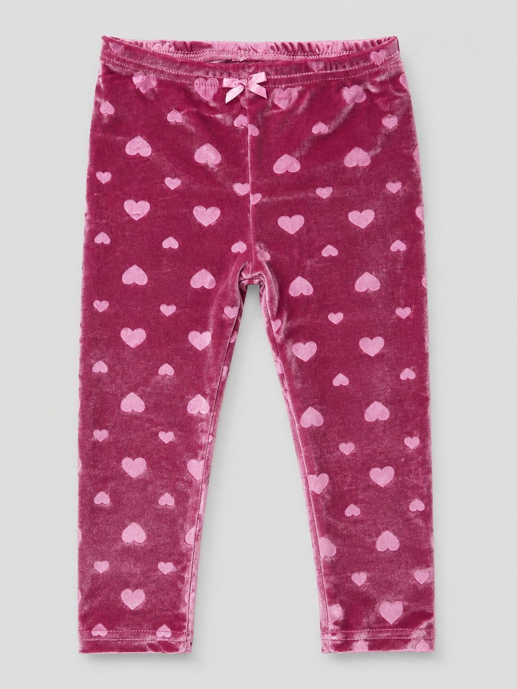 Girls' blush pink velvet leggings featuring an embossed heart design, stretchy fit, and soft plush fabric. Perfect for Valentine's Day, holidays, and cozy fall and winter outfits.