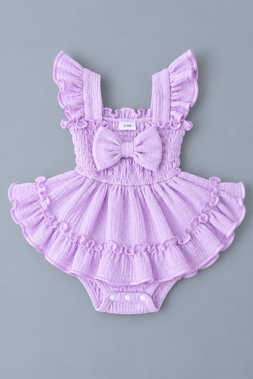 Baby girl lavender skirted romper with smocked bodice, front bow, flutter straps and layered ruffles
