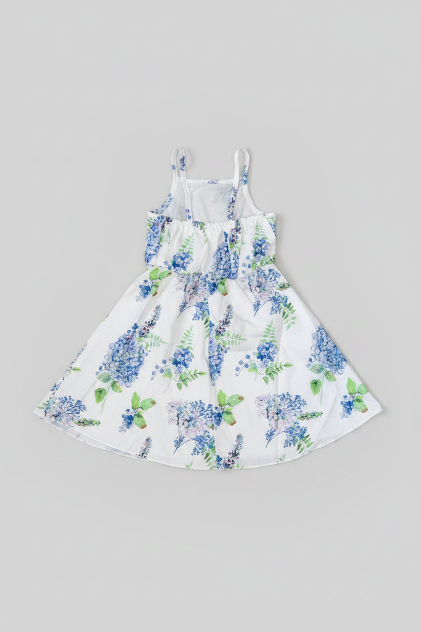 Back side of a  white sleeveless sundress with a blue and green floral print.