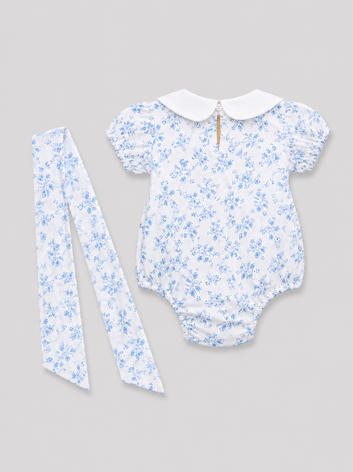 Baby girls white and light blue floral romper with Peter Pan collar, back keyhole button closure, and matching floral sash, back view, size 1–3M.