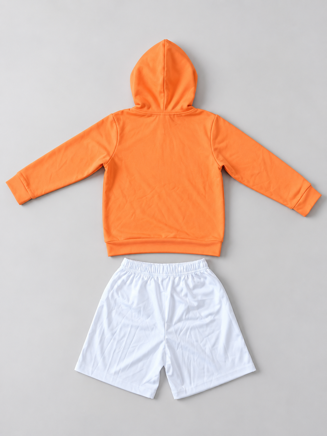 Kids orange hoodie and white elastic-waist shorts two-piece outfit, back view