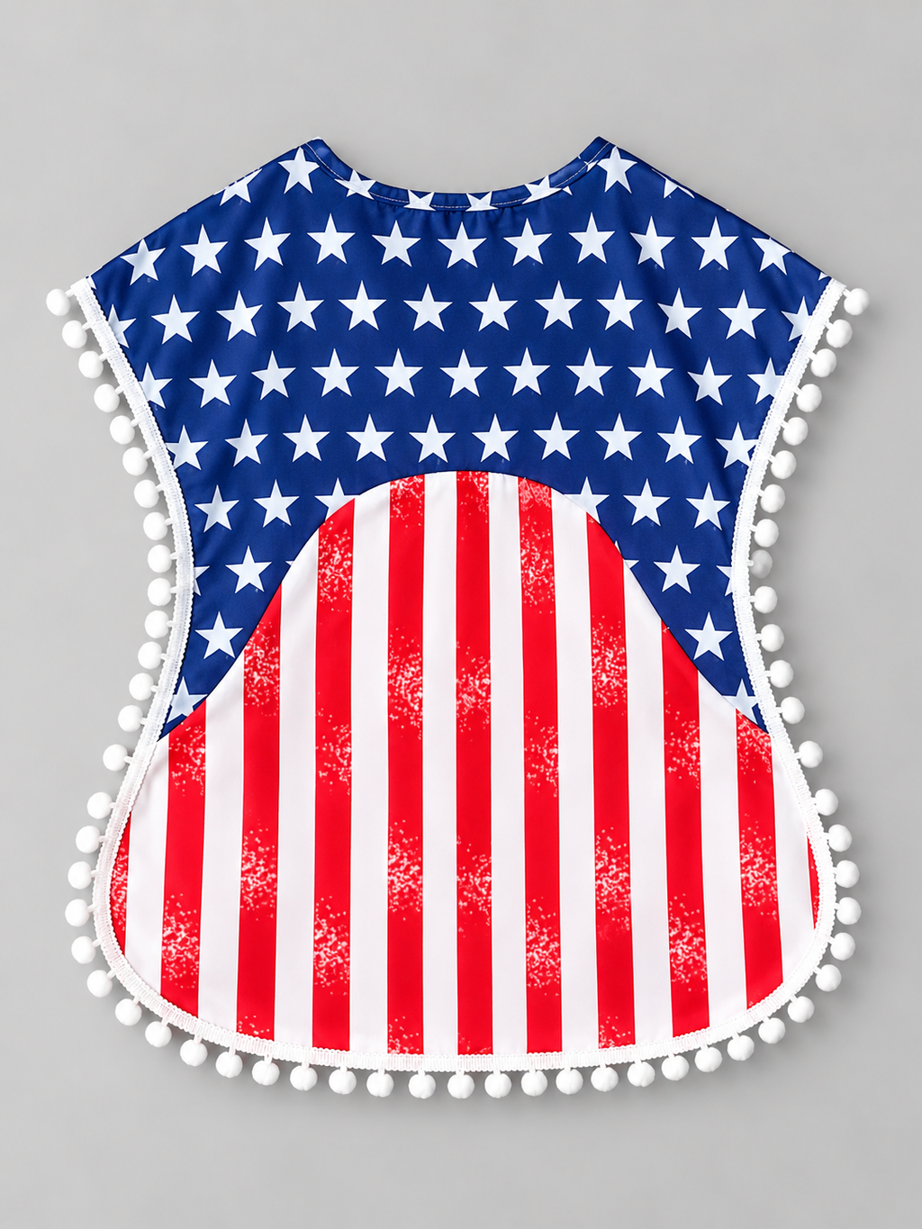 Back view of girls patriotic red white and blue dress with star print, striped skirt, and pom-pom trim