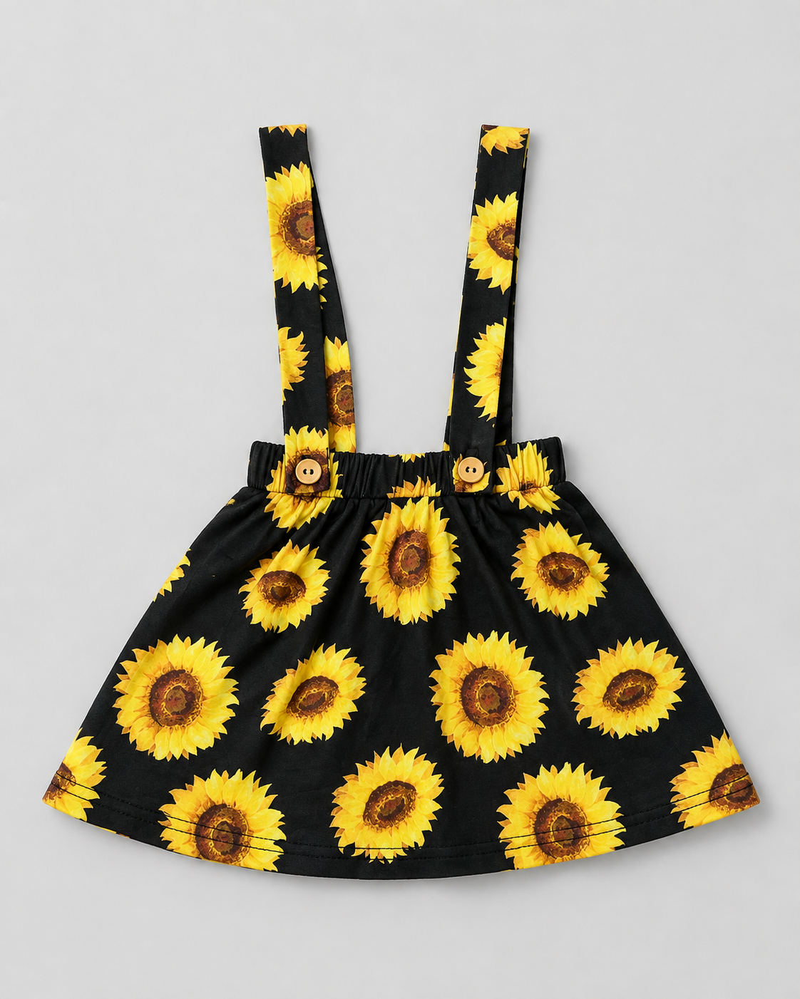 Shop this adorable black and sunflower girls dress featuring a vibrant sunflower print, gathered skirt, elasticized waist, and suspender-style shoulder straps. Perfect for everyday wear, summer outings, photos, and special occasions.