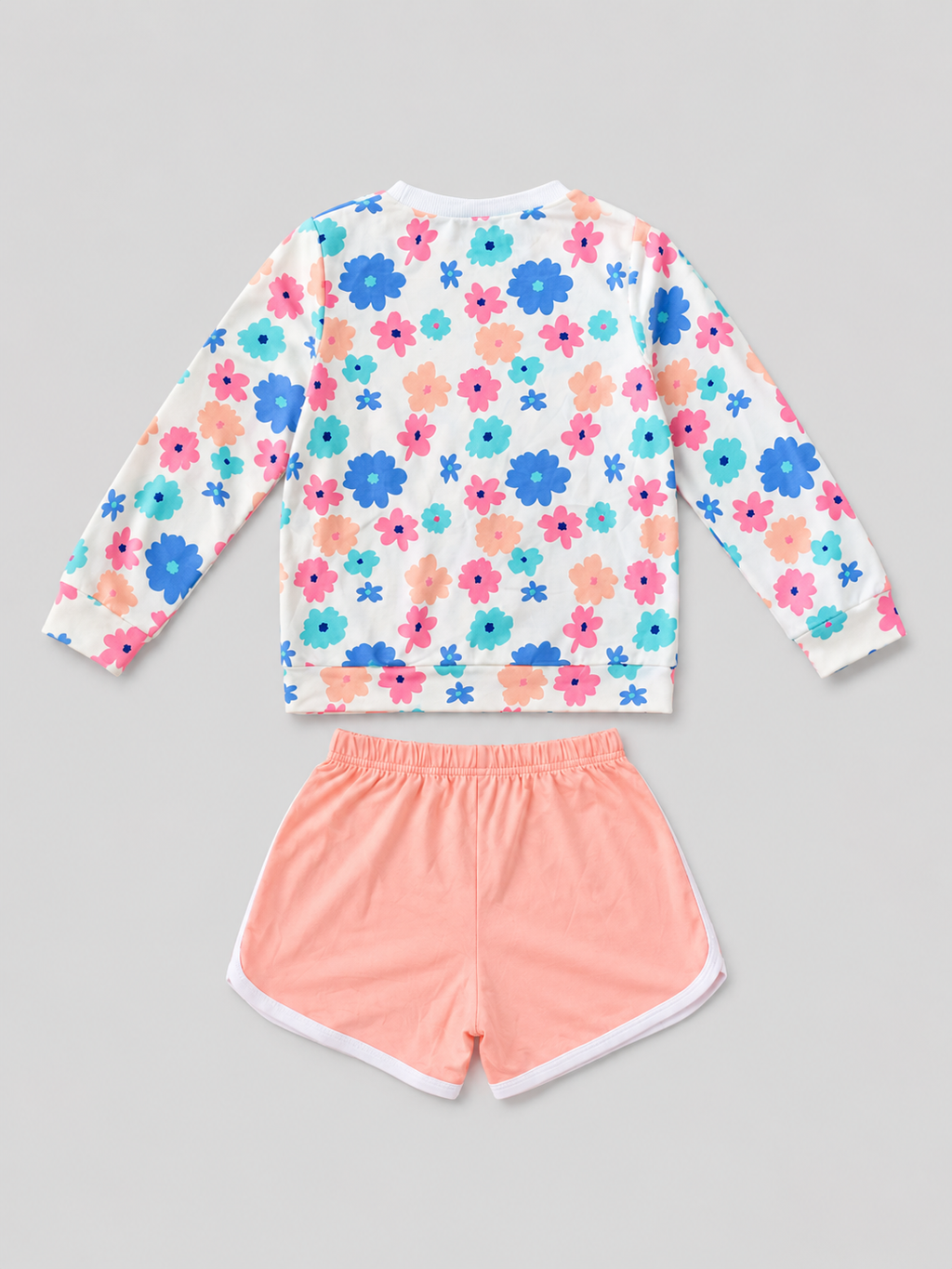 Shop this adorable girls’ two-piece set featuring a colorful floral long-sleeve top and coral shorts with white trim. Perfect for everyday wear, playdates, casual outings, and warm-weather activities.

