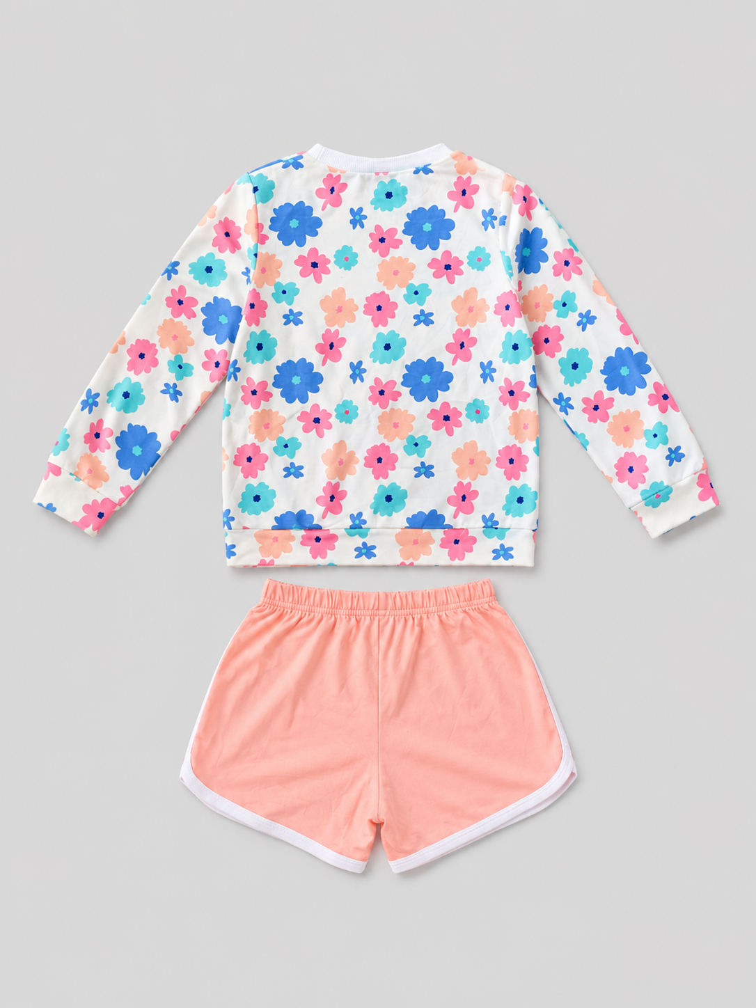 Shop this adorable girls’ two-piece set featuring a colorful floral long-sleeve top and coral shorts with white trim. Perfect for everyday wear, playdates, casual outings, and warm-weather activities.

