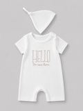 Shop this sweet white baby romper and matching knot hat set featuring textured fabric and an embroidered “Hello I’m new here” message. Perfect for newborn photos, coming-home outfits, and baby gifts.