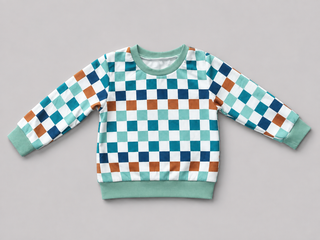 Shop this colorful kids long-sleeve sweatshirt featuring a retro checkerboard pattern in mint green, teal, navy, brown, and white with coordinating ribbed trim. Perfect for school, playtime, and everyday wear.

