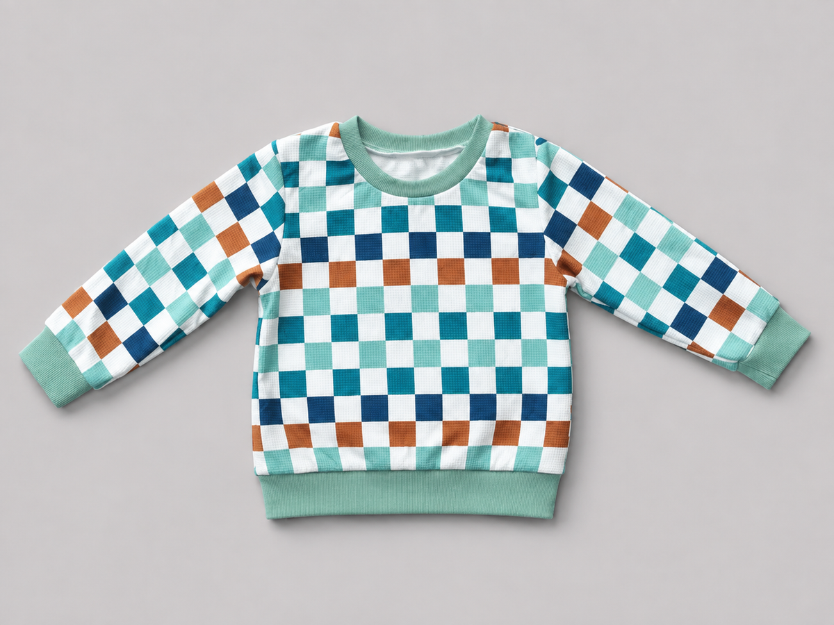 Shop this colorful kids long-sleeve sweatshirt featuring a retro checkerboard pattern in mint green, teal, navy, brown, and white with coordinating ribbed trim. Perfect for school, playtime, and everyday wear.

