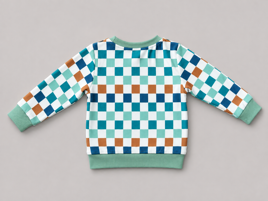 Shop this colorful kids long-sleeve sweatshirt featuring a retro checkerboard pattern in mint green, teal, navy, brown, and white with coordinating ribbed trim. Perfect for school, playtime, and everyday wear.

