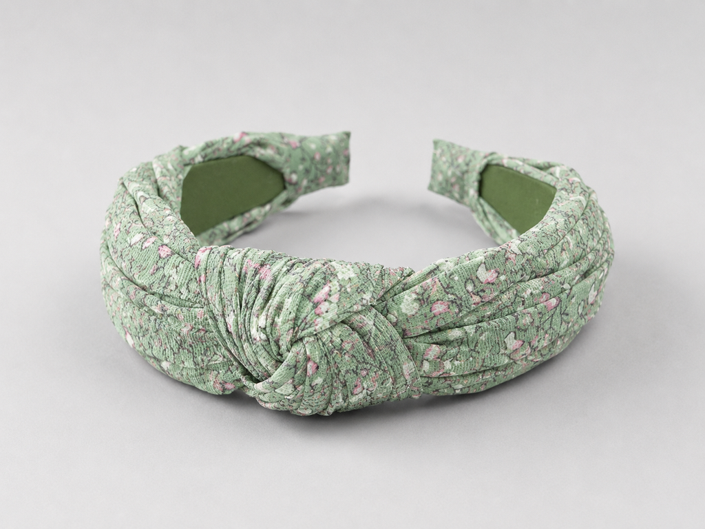 Headband for this sage green and white striped girls blouse featuring a sleeveless design, gathered ruffle hem, and natural-tone back buttons. A fresh and versatile top for everyday wear, school, vacations, and special outings.