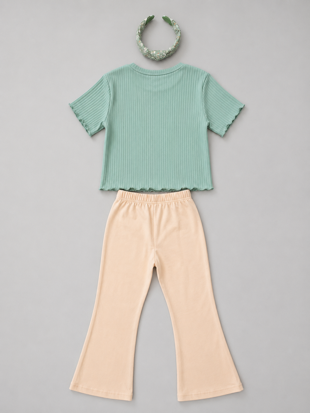 Shop this sage green and white striped girls blouse featuring a sleeveless design, gathered ruffle hem, and natural-tone back buttons. A fresh and versatile top for everyday wear, school, vacations, and special outings.