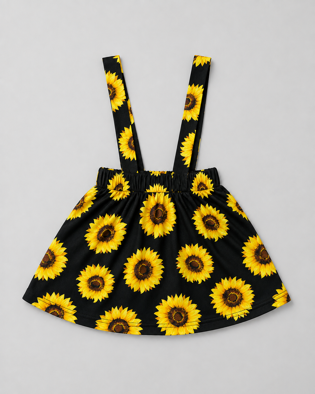 Shop this adorable black and sunflower girls dress featuring a vibrant sunflower print, gathered skirt, elasticized waist, and suspender-style shoulder straps. Perfect for everyday wear, summer outings, photos, and special occasions.