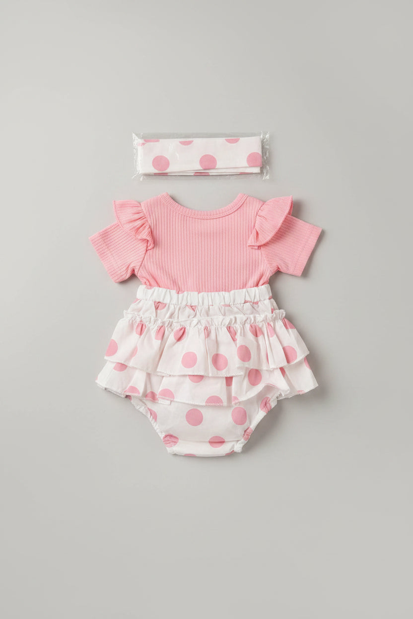 Baby girl pink polka dot bubble romper featuring an embroidered teddy bear applique, flutter sleeves, layered ruffles, and a matching headband. A boutique outfit perfect for birthdays, family photos, baby showers, and everyday wear.