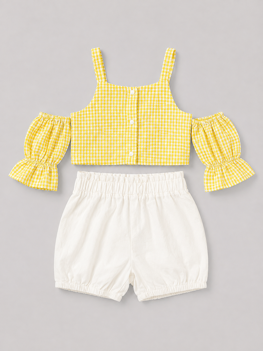 Yellow gingham girls' two-piece outfit featuring a puff-sleeve button-front top and coordinating white bloomer shorts. A sweet summer set for everyday wear, vacations, and special occasions.