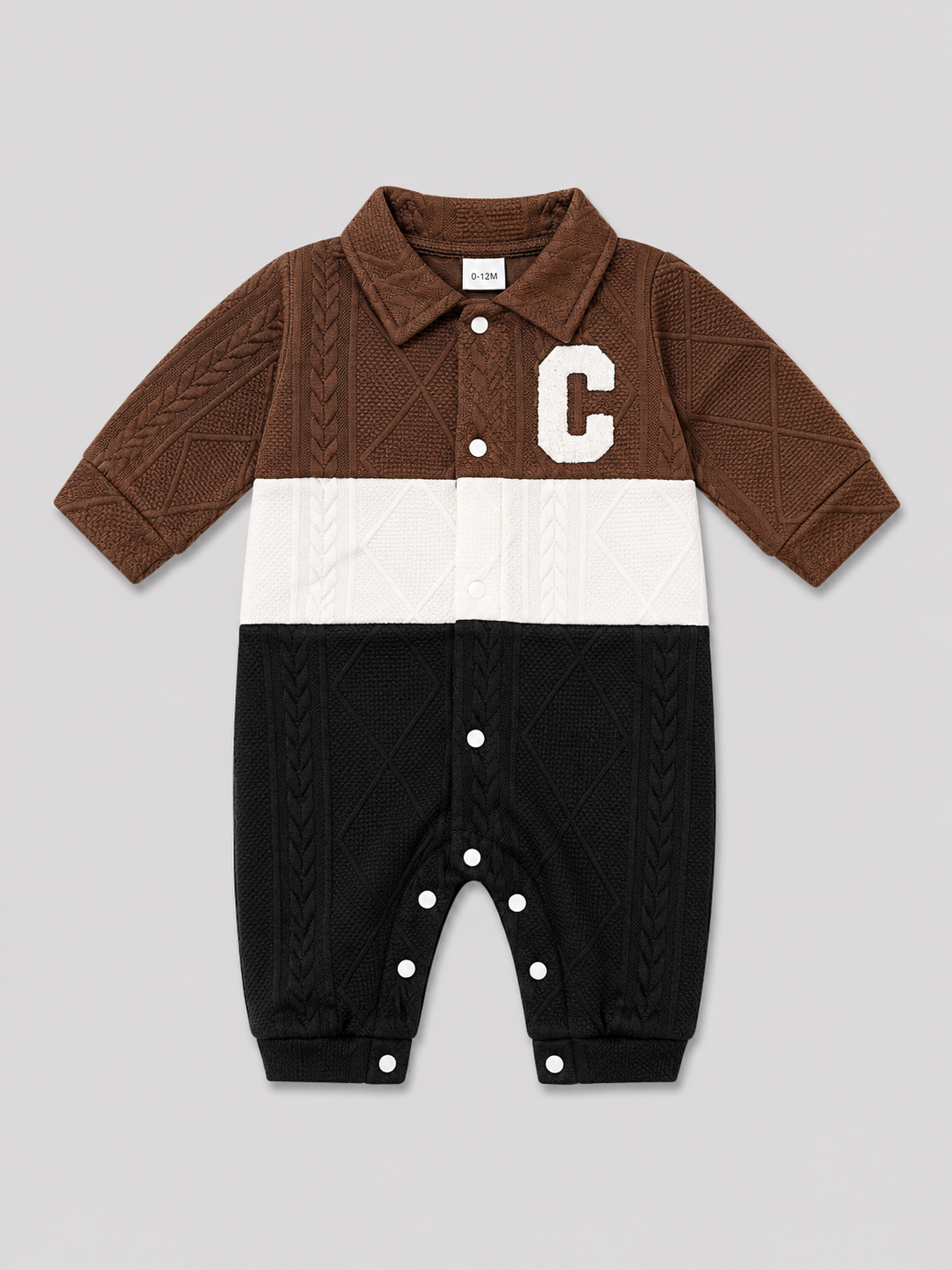 Shop this stylish brown, cream, and black cable knit baby romper featuring a textured design, collared neckline, button front, and convenient snap closures. Perfect for baby boys or girls.