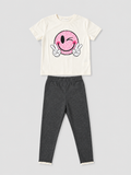 Girls ivory T-shirt with pink winking smiley face graphic and charcoal gray lace-trim leggings two-piece outfit, front view, size 4Y.