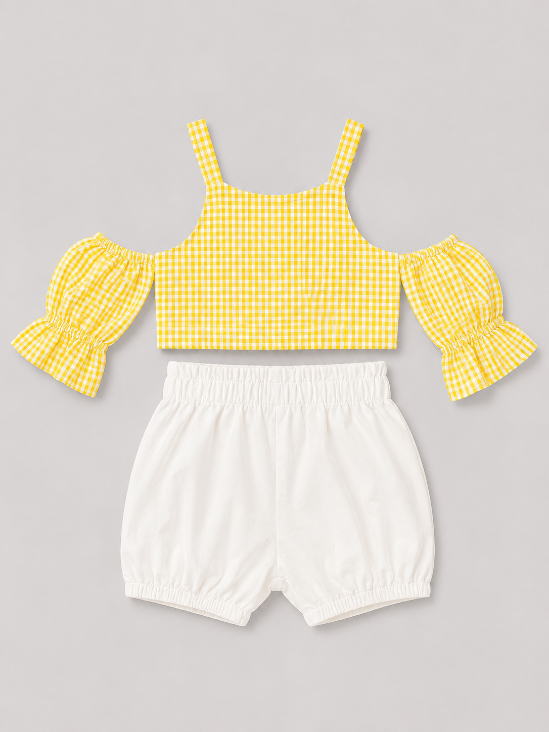 Yellow gingham girls' two-piece outfit featuring a puff-sleeve button-front top and coordinating white bloomer shorts. A sweet summer set for everyday wear, vacations, and special occasions.