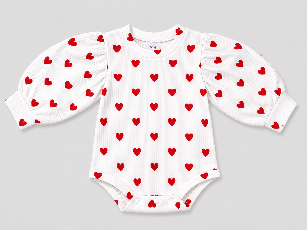 Adorable baby girls' white ribbed bodysuit featuring a red heart print, long puff sleeves, and snap closures. Soft, comfortable, and perfect for Valentine's Day or everyday wear.