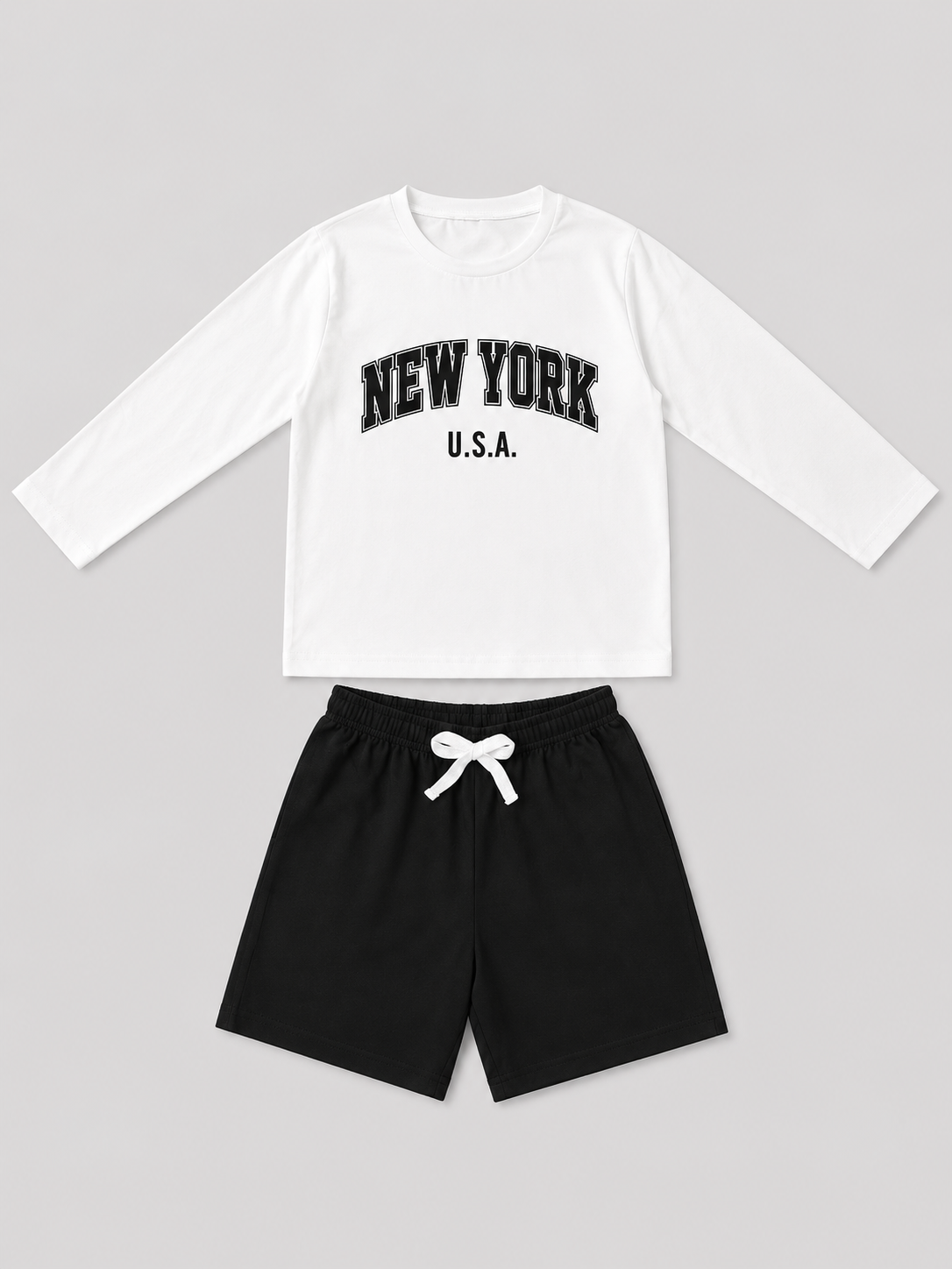 Boys white long-sleeve New York U.S.A. graphic shirt with black drawstring shorts two-piece outfit, front view, size 5–6Y.
