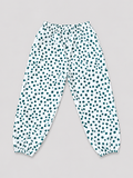 Girls white jogger pants with teal polka dot print, elastic waistband, and gathered ankle cuffs, front view, size 8–10Y.