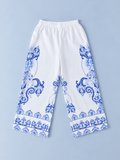 Girls white wide-leg pants with blue paisley-inspired border print and elastic waistband