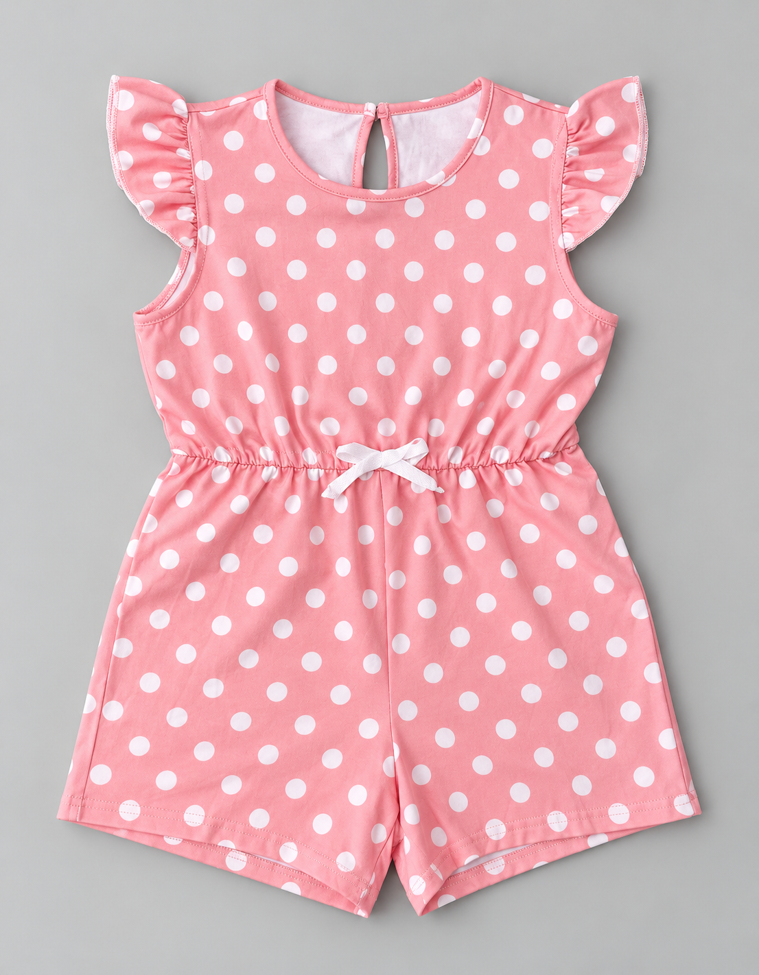 Girls pink and white polka dot romper with ruffle sleeves, elastic waist, and white bow detail