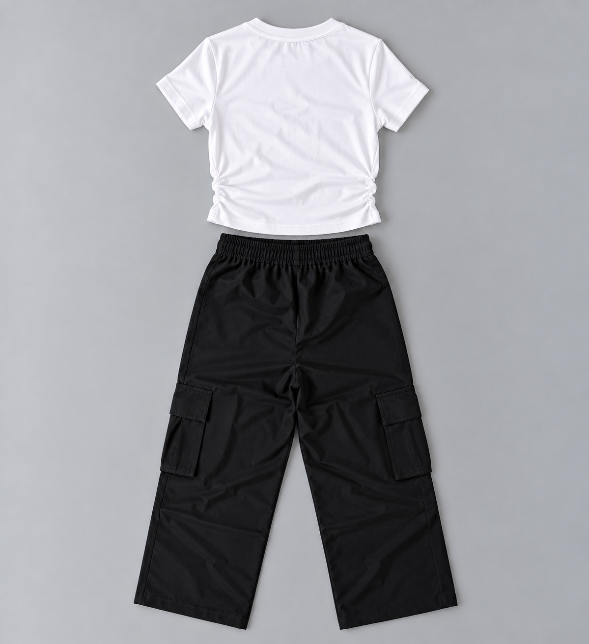 Back view of girls white ruched-side short-sleeve top with black elastic-waist cargo pants